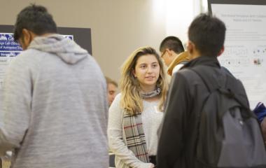 students talking at research fair