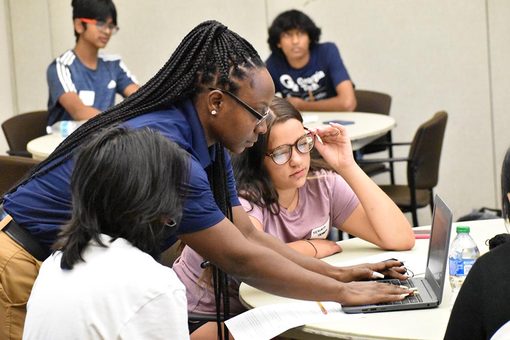 students stand around computer