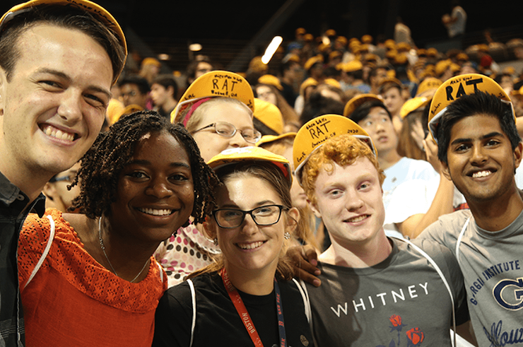 students smiling in yellow hats