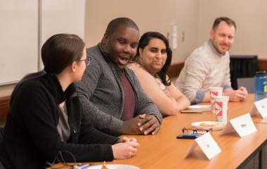 students and faculty at a table session