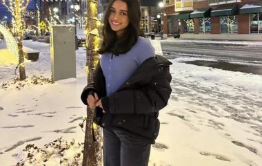 student Vibha Narasayya poses in front of a tree with snow on the ground