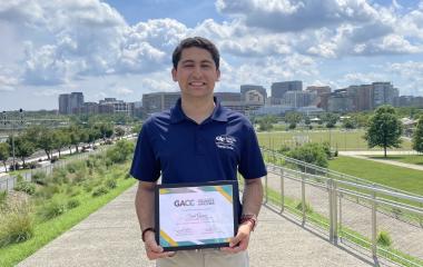 Said Gomez holding the Jack Mangham Experiential Learning Award. 