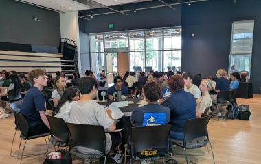 Students gather at tables to listen about different experiential learning programs.