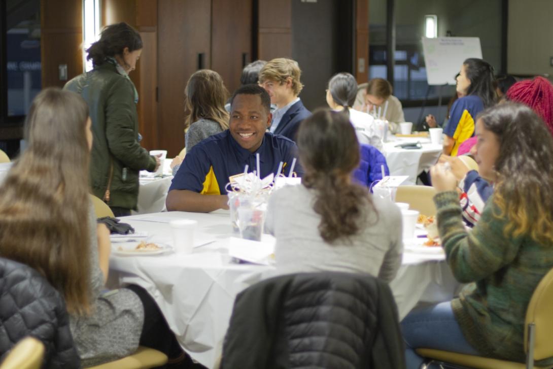 students smiling around a table