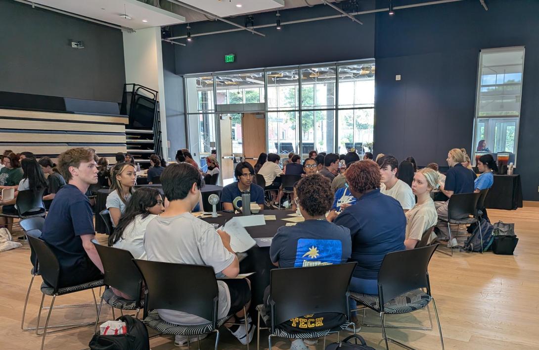Students gather at tables to listen about different experiential learning programs.